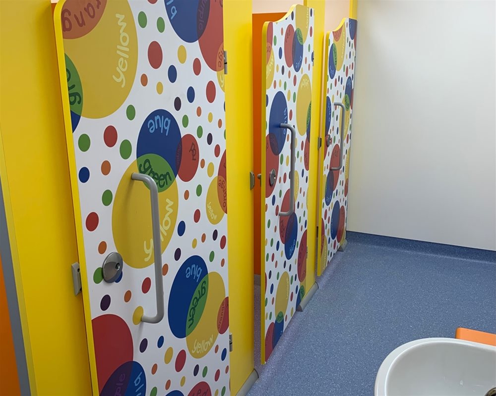 Colourful spotty doors in a childrens washroom in the Heathrow case study