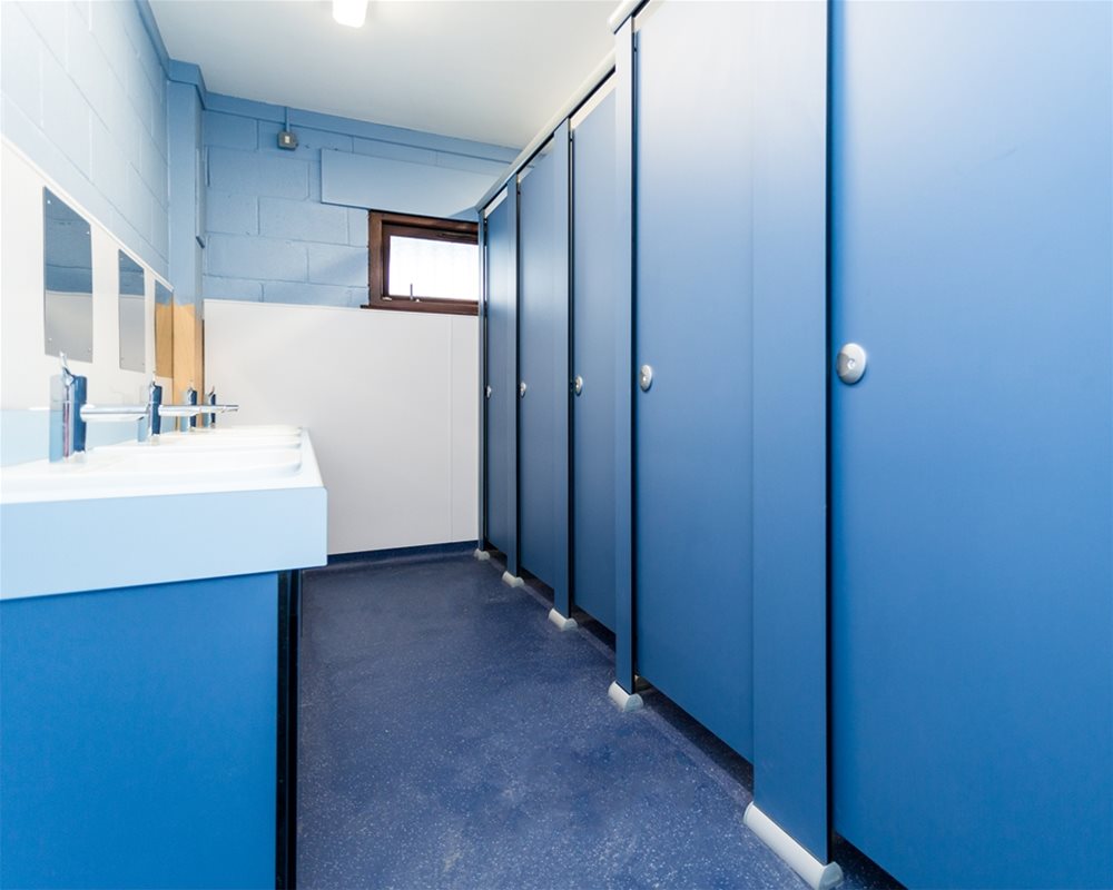 Quadro Toilet Cubicle in 'Air Force Blue' with countertop vanity unit in 'pastel blue' and underframe in 'air force blue'