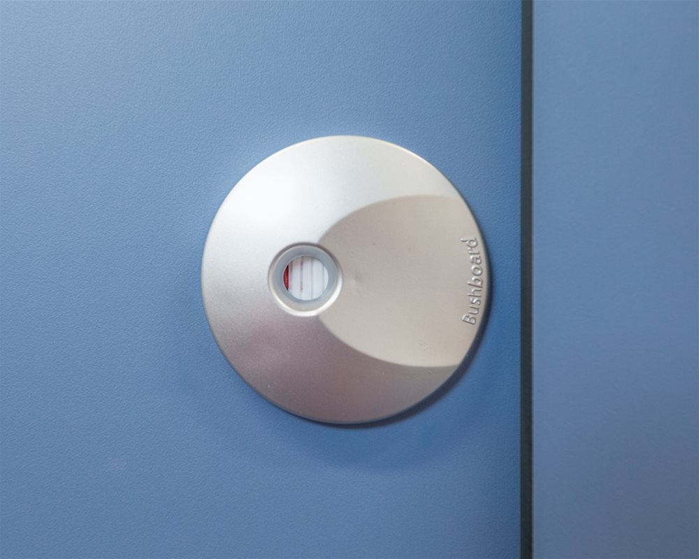 Silver plastic lock faceplate with white indicator on 'Air Force Blue' toilet cubicle door.