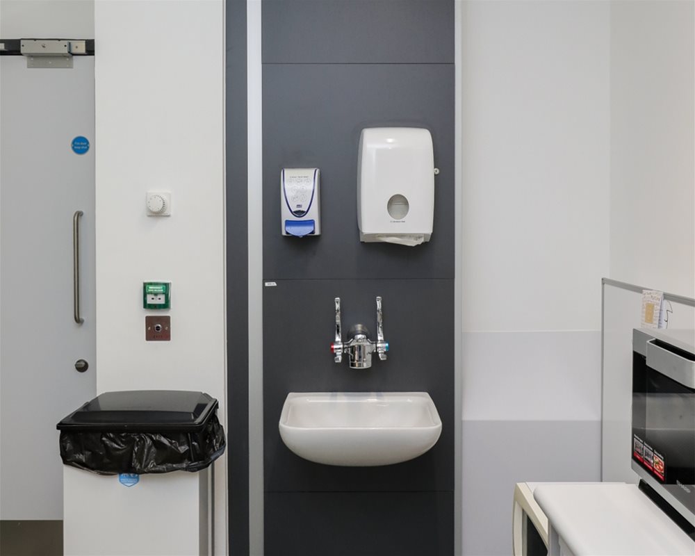 Healthcare IPS boxed out unit in 'Slate Grey' with clinical wash basin and wall mounted lever healthcare taps in hospital room.