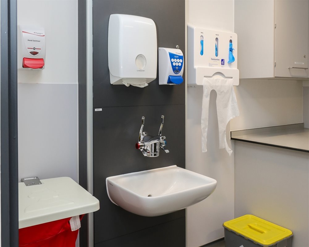 Healthcare IPS boxed out unit in 'Slate Grey' with clinical wash basin and wall mounted lever healthcare taps in hospital room.