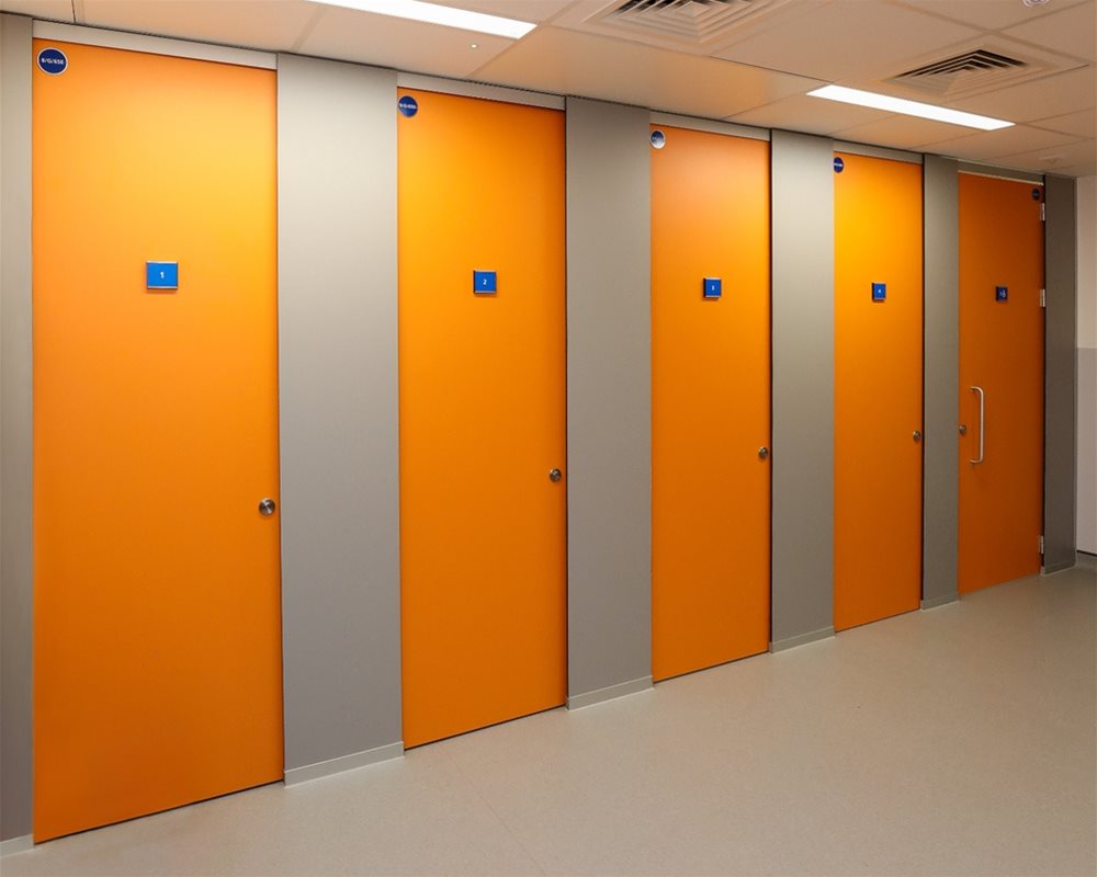 HiZone full height toilet cubicle with 'Orange' and 'Light Grey' pilasters offering total privacy as a changing cubicle with benching inside.
