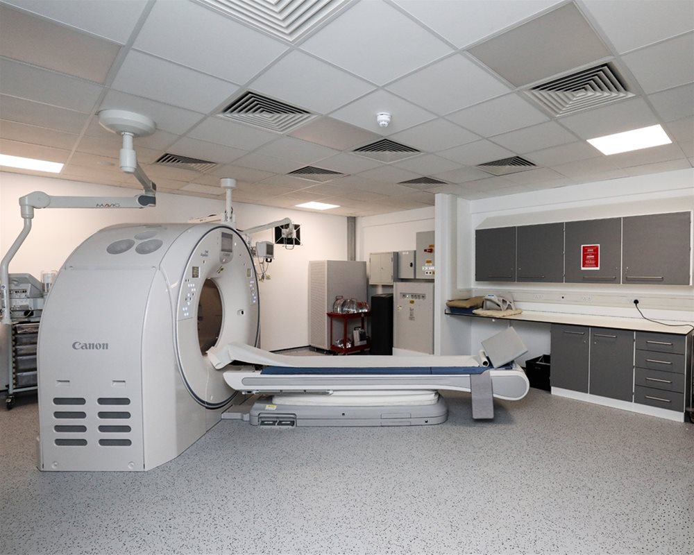 CT scanner in hospital room with healthcare IPS boxed out unit with clinical wash hand basin at the side of the image.