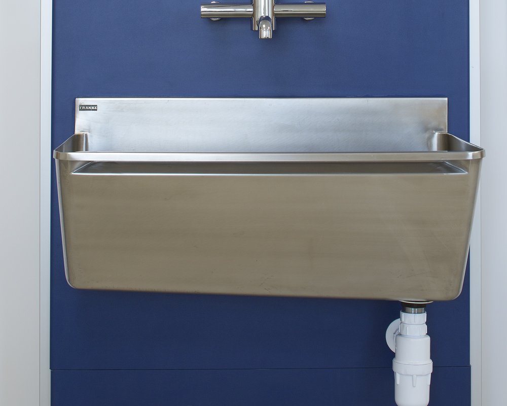 Stainless steel surgical scrup up trough and tap pre-plumbed on blue IPS panels.