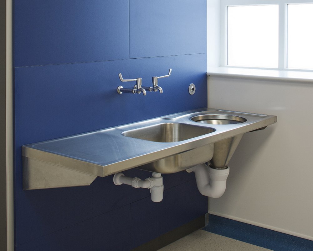 Stainless steel clinical disposal unit, sink and taps pre-plumbed on blue IPS panels