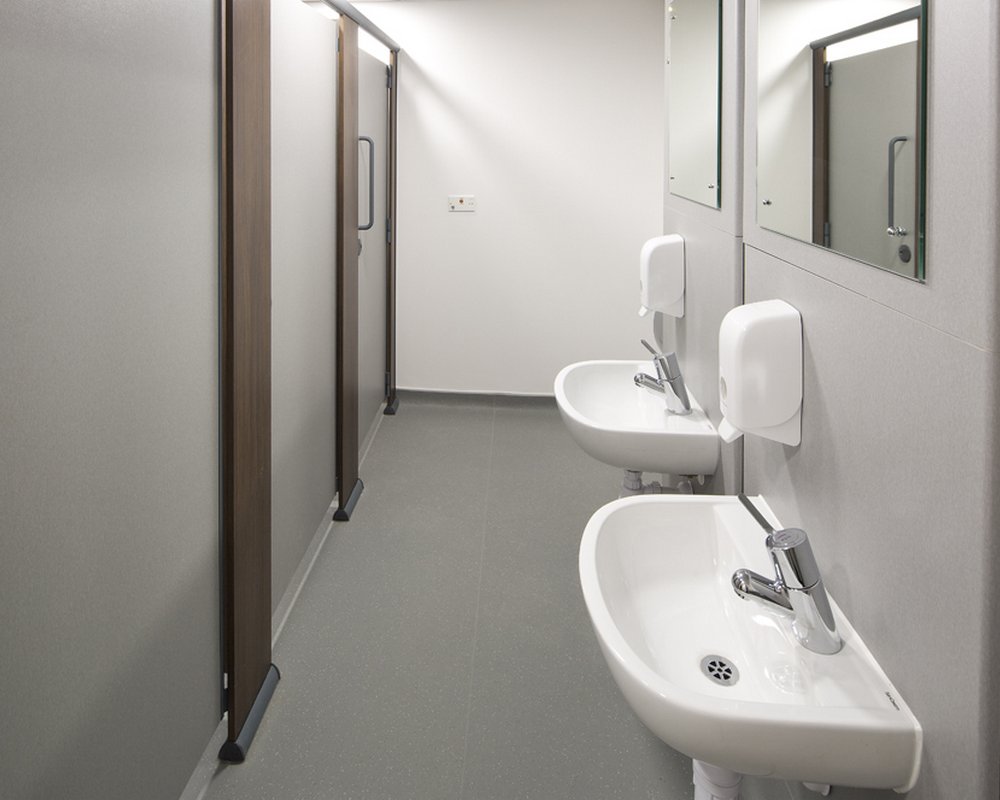 Quadro toilet cubicles in Winter and Walnut colours with wall hung SanCeram basins