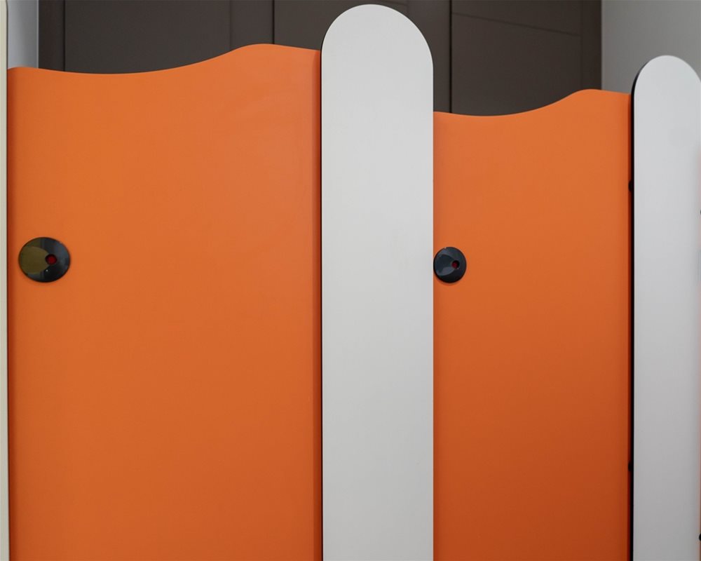 Tiny Stuff lower height toilet cubicles in 'Tangerine' orange and 'Arctic' white
